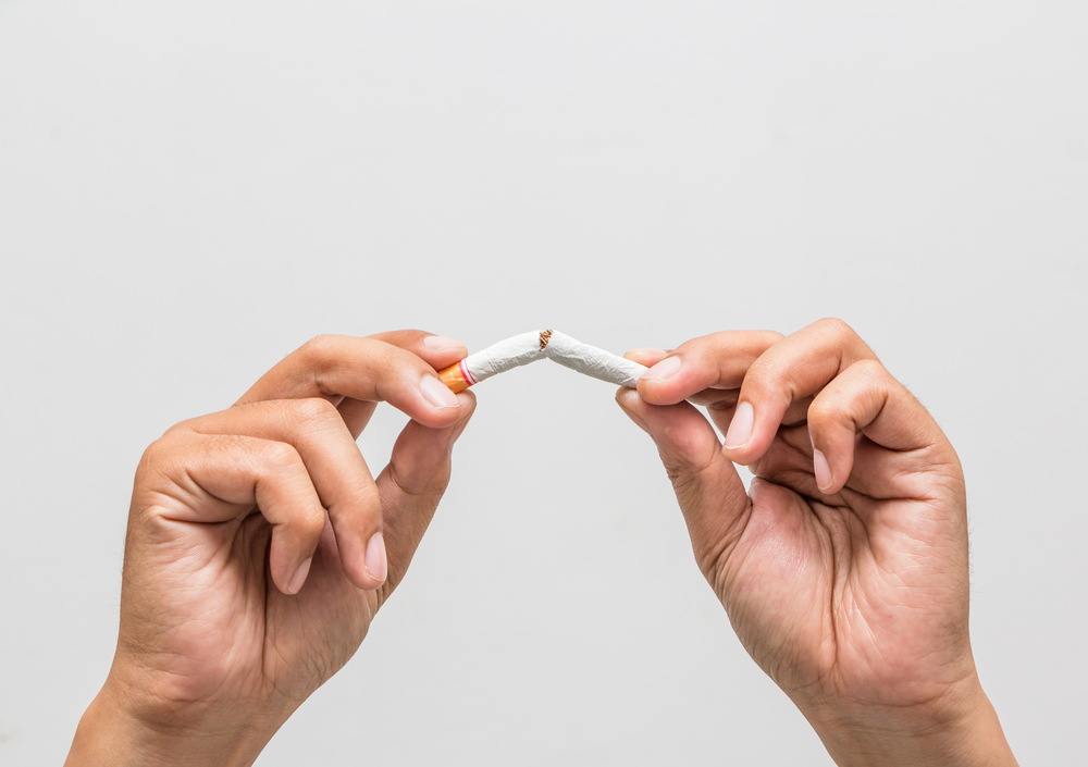 Male hand crushing cigarette