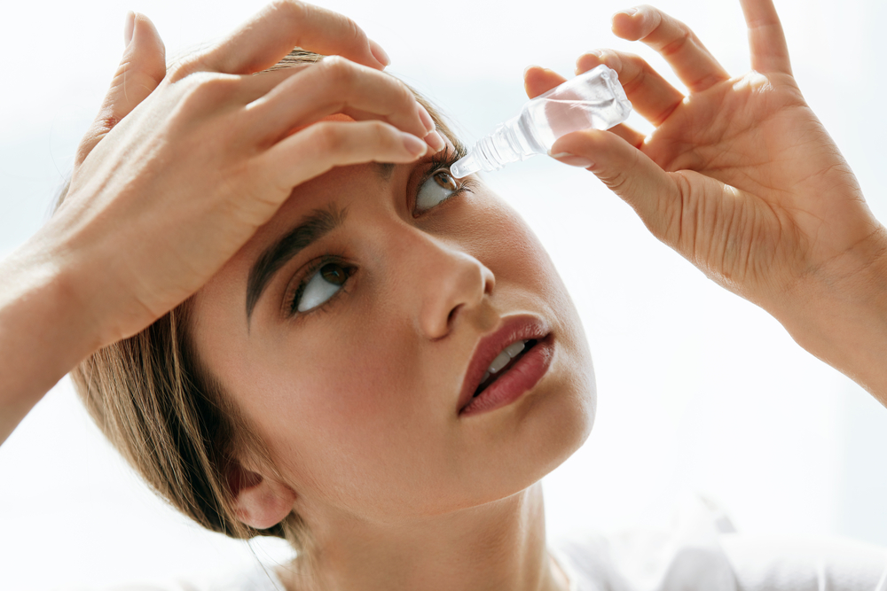 Girl Pouring Eye Drops into Her Eyes